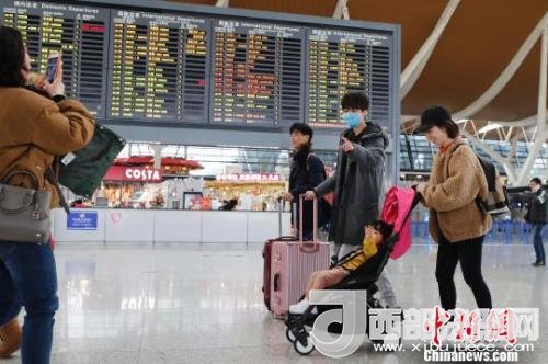 旅客帶著孩子前往辦票柜臺辦理登機(jī)手續(xù)?！∫罅⑶?攝
