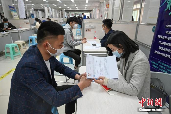4月14日，招聘者在查看求職者簡(jiǎn)歷。<a target='_blank'  data-cke-saved- >中新社</a>記者 王剛 攝