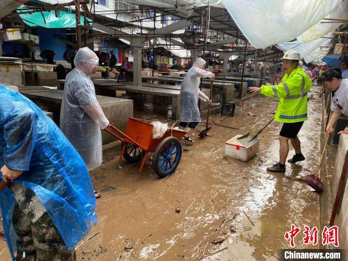 圖為7月26日，暴雨引發(fā)的洪水過境后，重慶萬州區(qū)分水鎮(zhèn)政府干部職工及志愿者清掃淤泥和垃圾?！　≈貞c萬州區(qū)委宣傳部供圖 攝