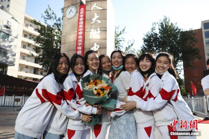 資料圖：6月10日，在北京人大附中高考考點(diǎn)外，考生們相擁拍照留念。當(dāng)日，北京市2021年高考結(jié)束?！?<a target='_blank'  data-cke-saved- ><p  align=
